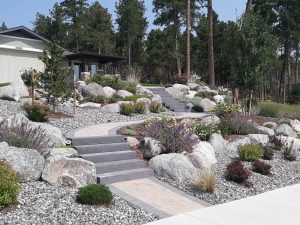 Landscape design in Colorado Springs featuring a professionally built retaining wall and stone pathway.