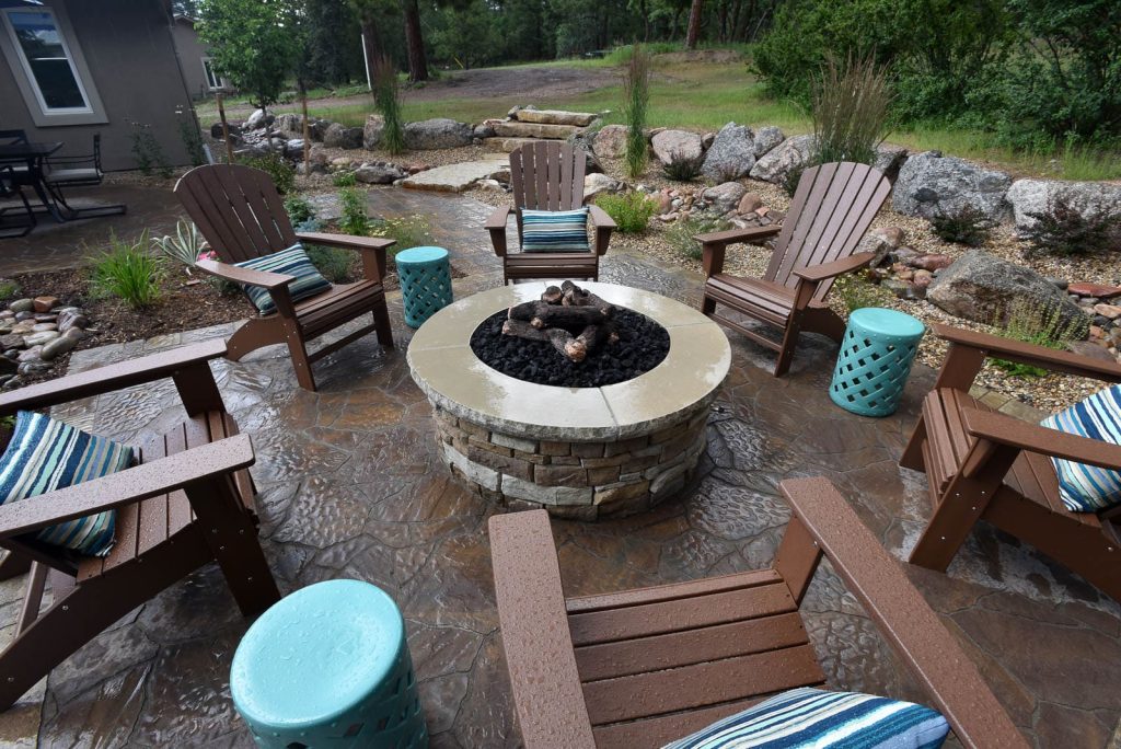 Image of a backyard patio installation with integrated landscape design and fire feature in Colorado Springs