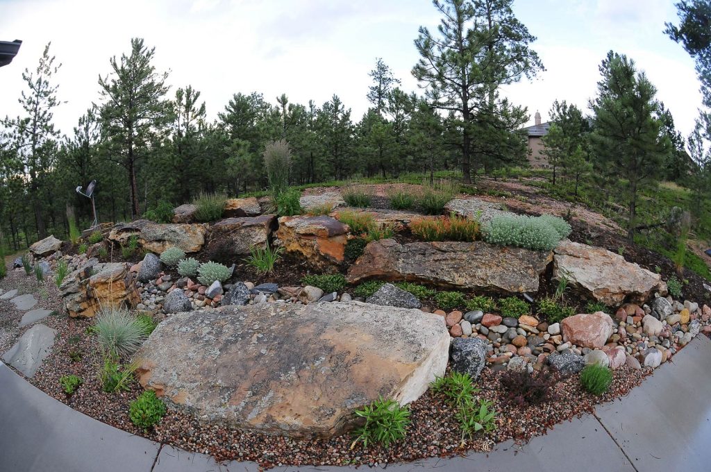 Image of a custom backyard landscape design project in Colorado Springs with natural stone surfaces