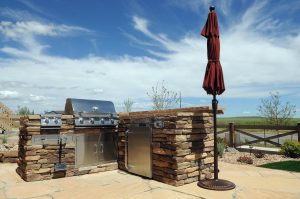 Luxurious outdoor kitchen in Colorado Springs with barbecue grill for backyard entertaining and dining.