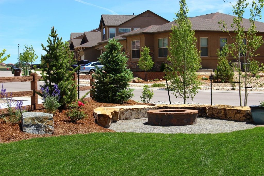 Image of a natural stone outdoor patio with fire feature and landscape design in Colorado Springs